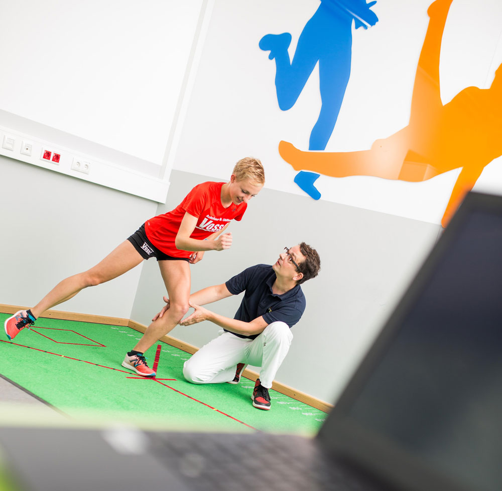 Frau beim Bewegungstraining mit Physiotherapeuten in Sportphysiotherapie in Münster